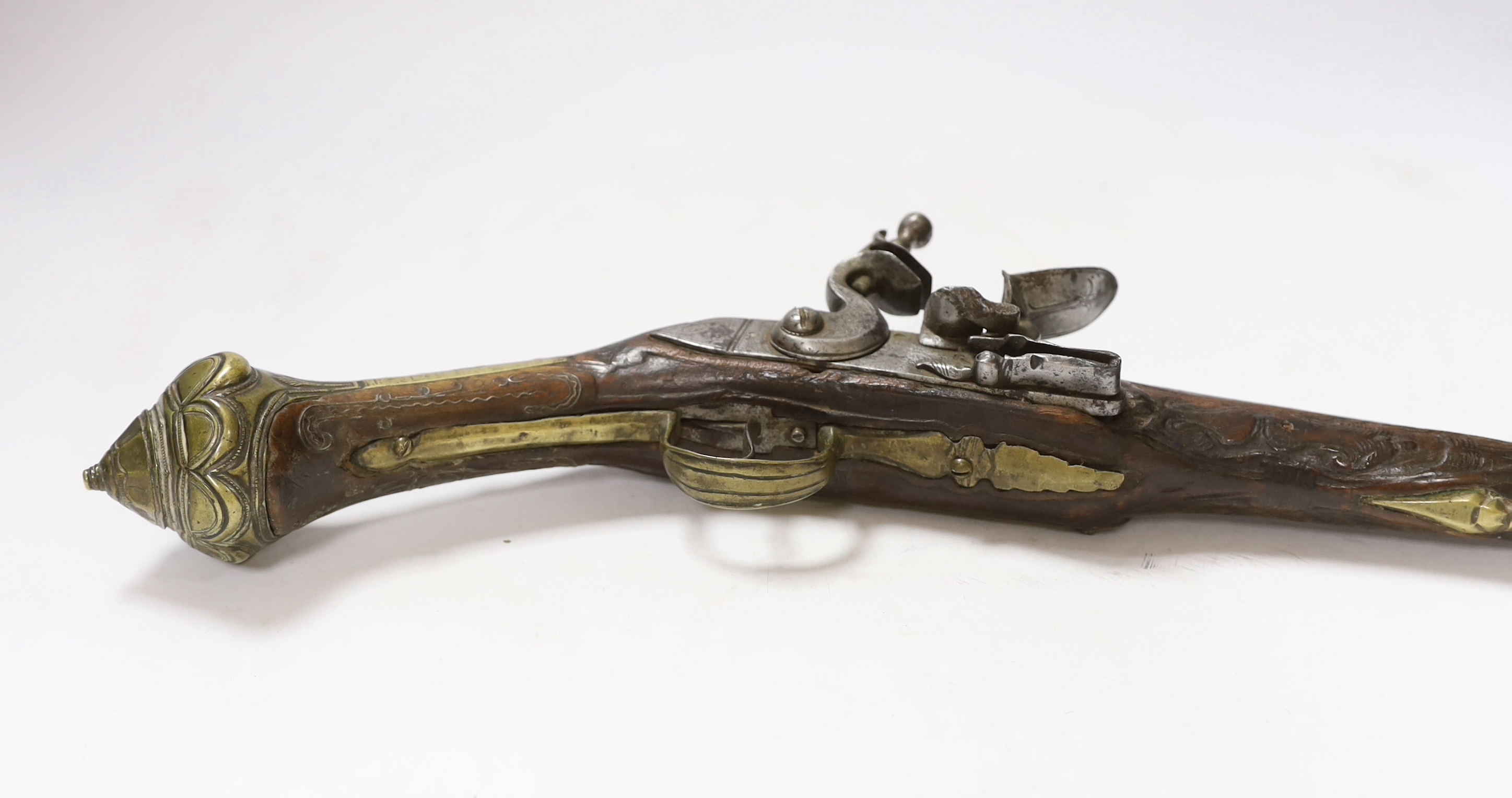 A Turkish Flintlock holster pistol with brass mounts, long spur butt cap, engraved lock and carved stock, barrel 29.5cm